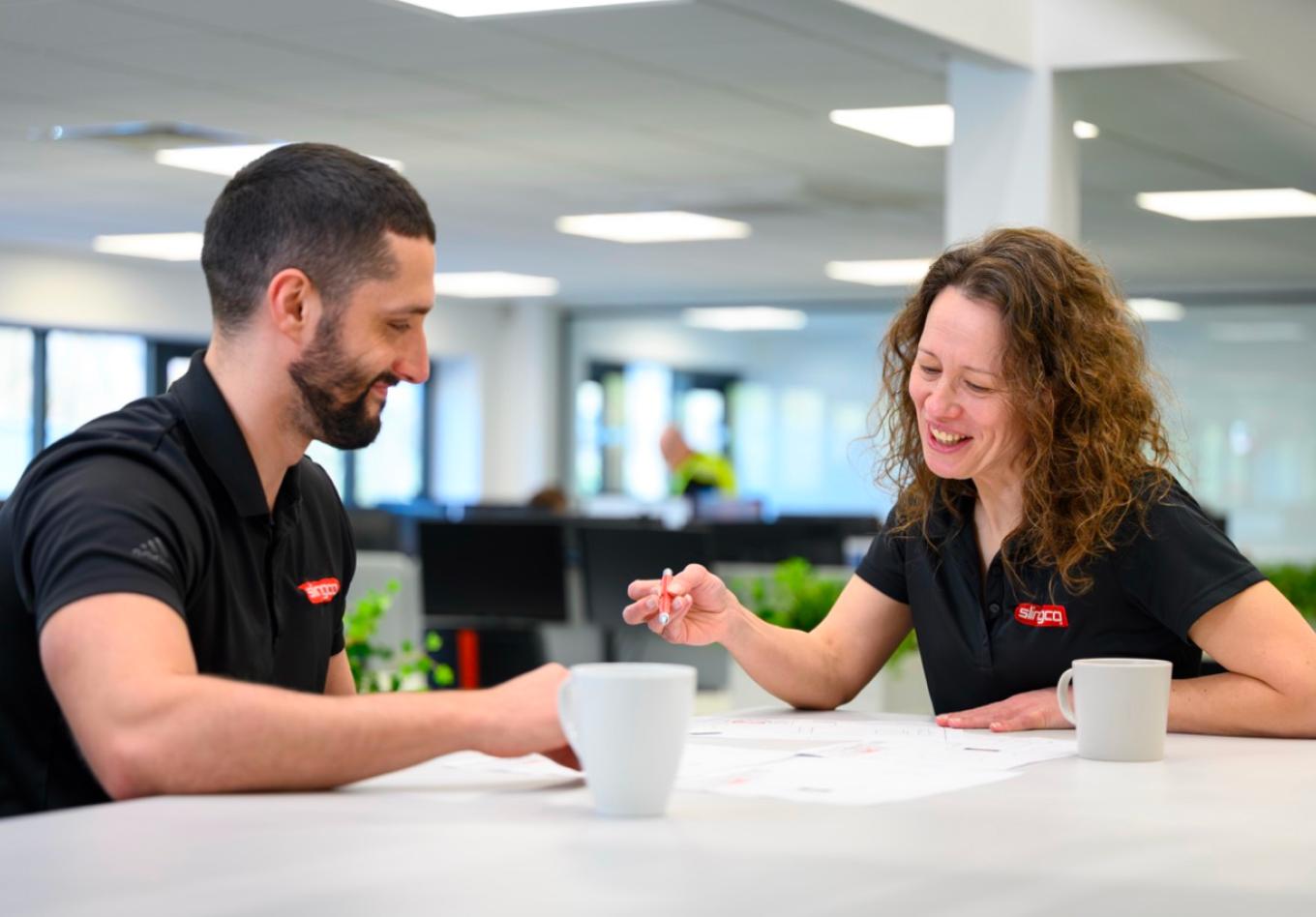Two Slingco employees working together at a table
