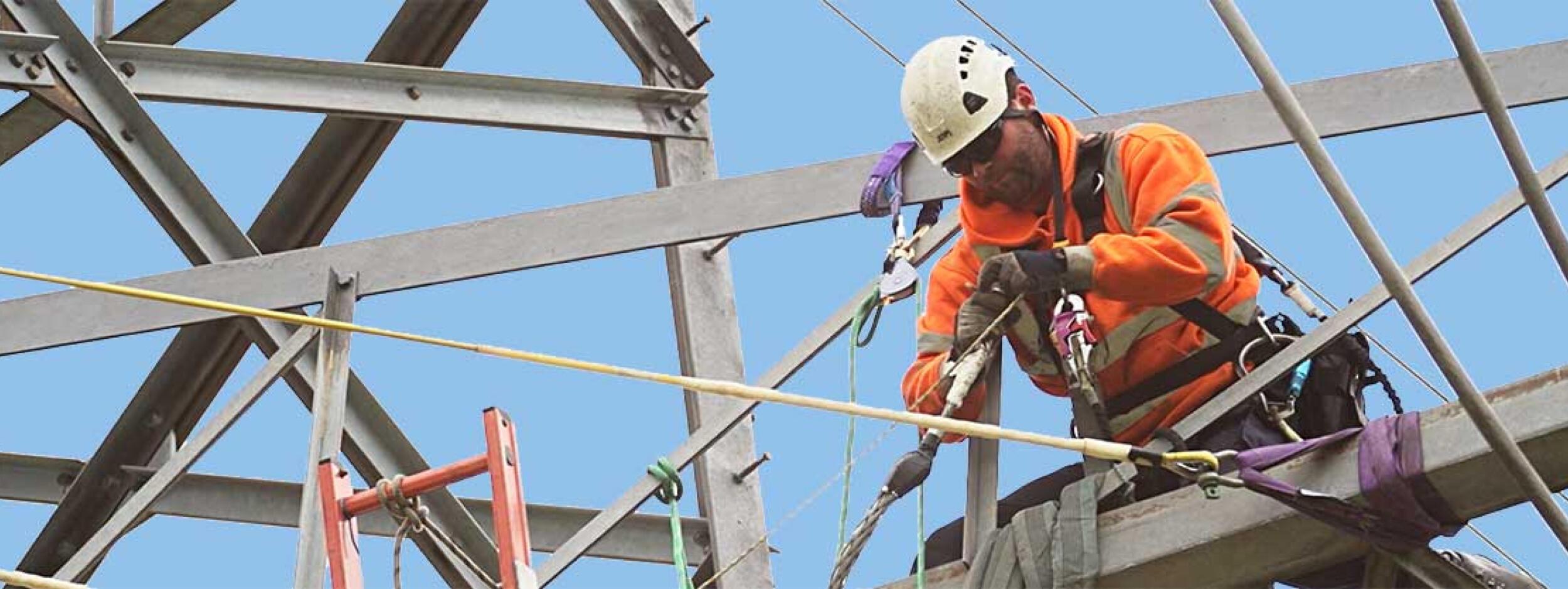 Linesman working at height on a transmission tower