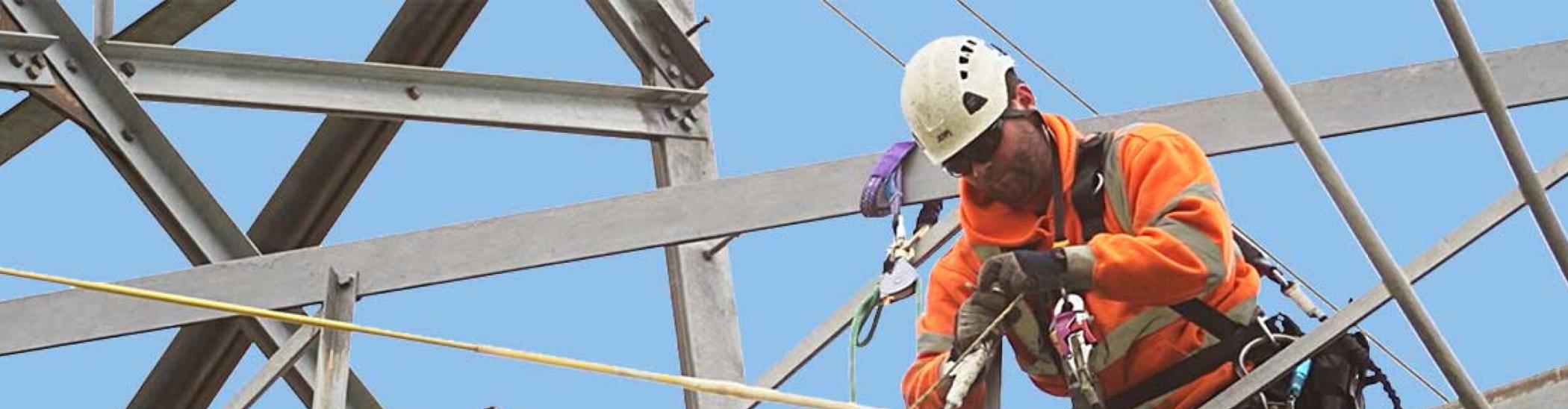 Linesman working at height on a transmission tower