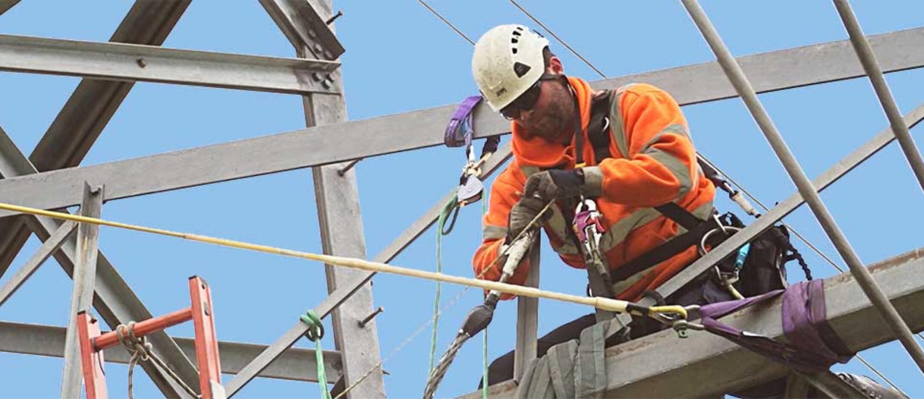Linesman working at height on a transmission tower