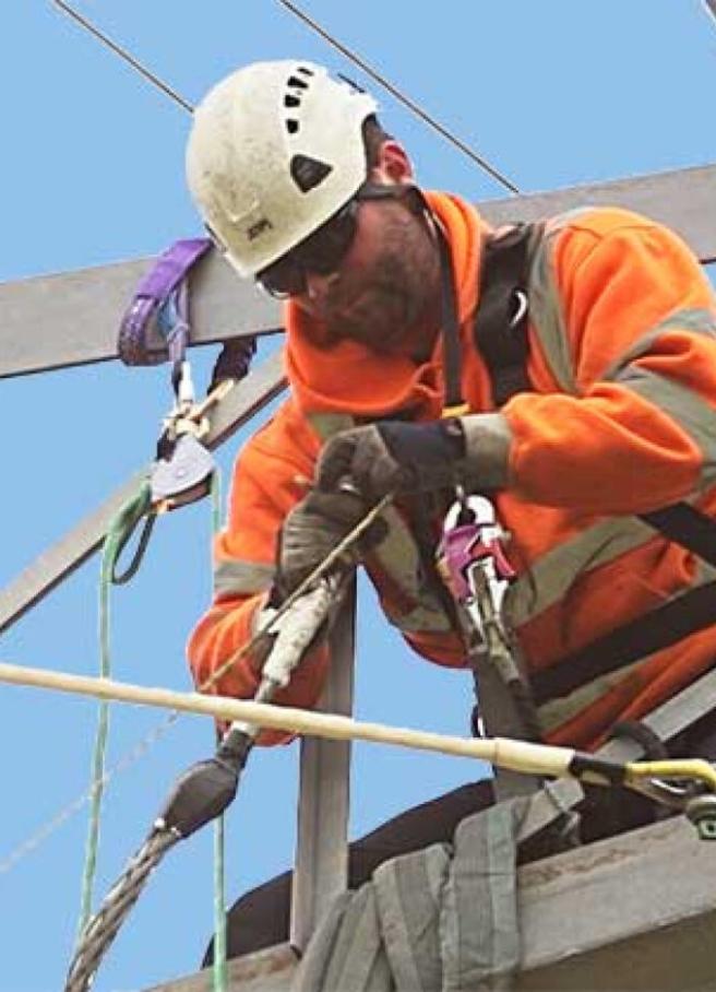 Linesman working at height on a transmission tower