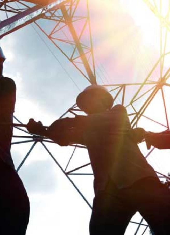 Line crew pulling a rope at an electricity pylon