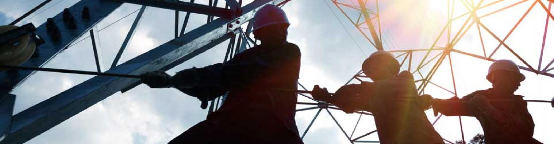 Line crew pulling a rope at an electricity pylon