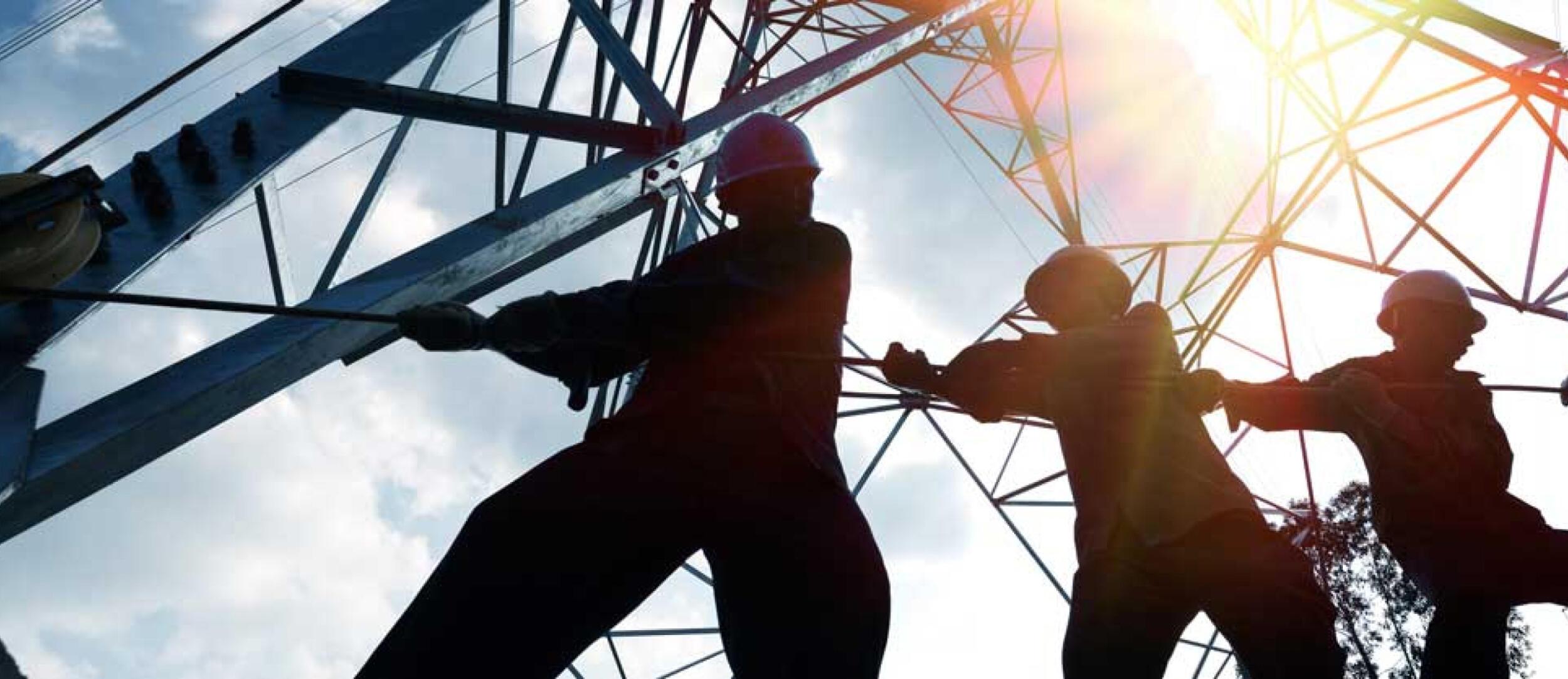 Line crew pulling a rope at an electricity pylon