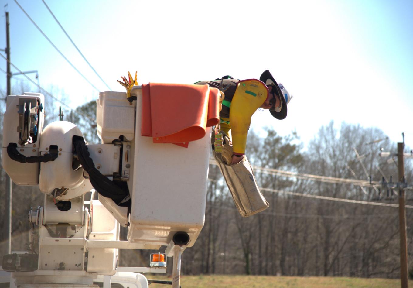 Linesman working from a cherry picker on overhead lines