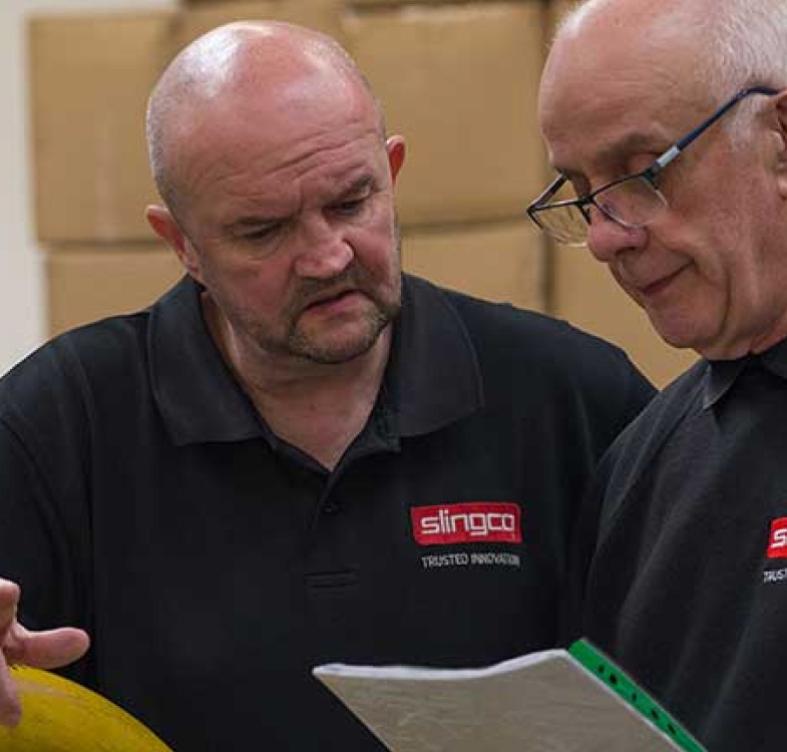 Two Slingco employees talking over a clipboard